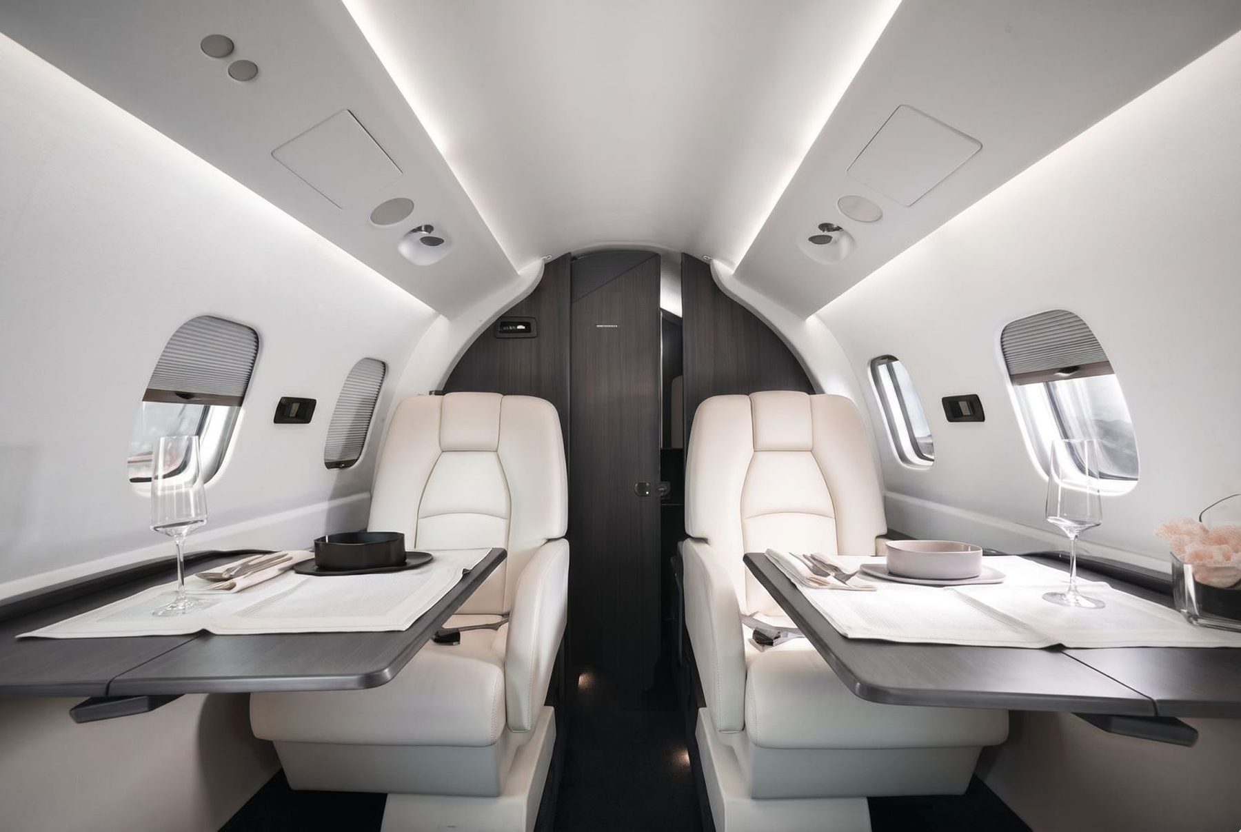 Avanti cabin looking forward: two facing club seats with dining tables laid